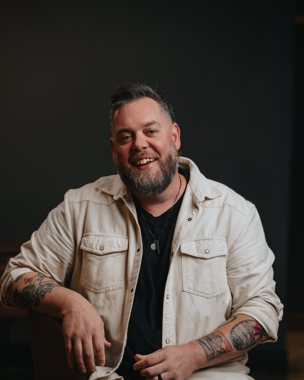 Drew Powell seated, smiling toward the camera